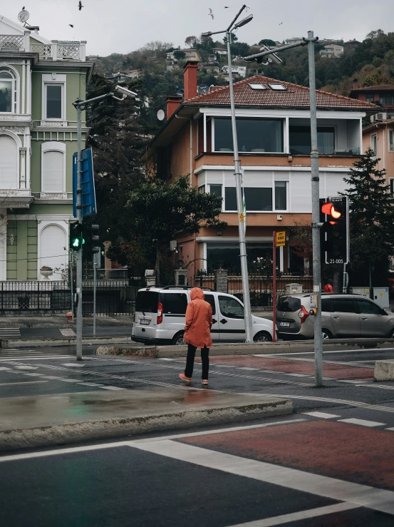 a woman crossing the street in front of some buildings