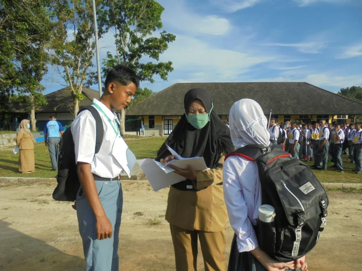 two people with masks on standing next to each other and a group of people