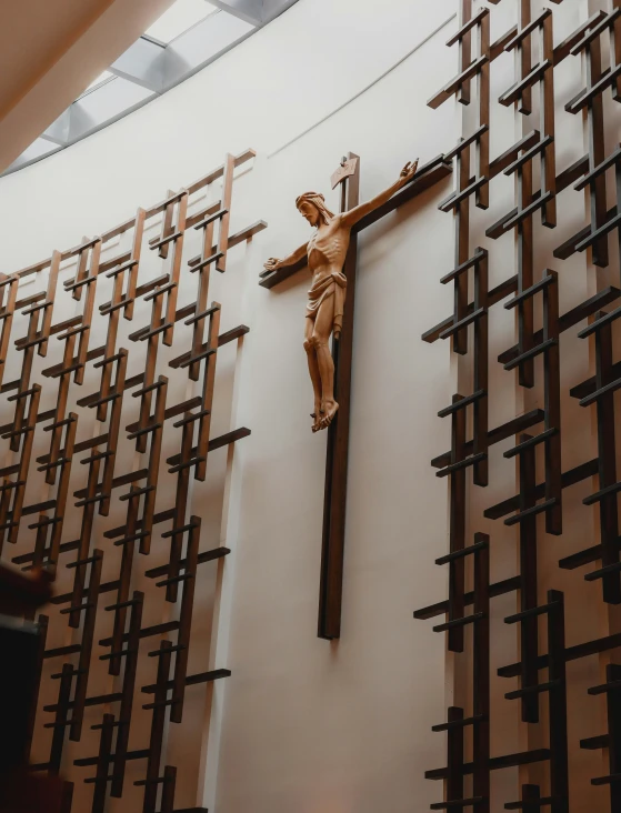 a statue of jesus on the cross mounted to a wall