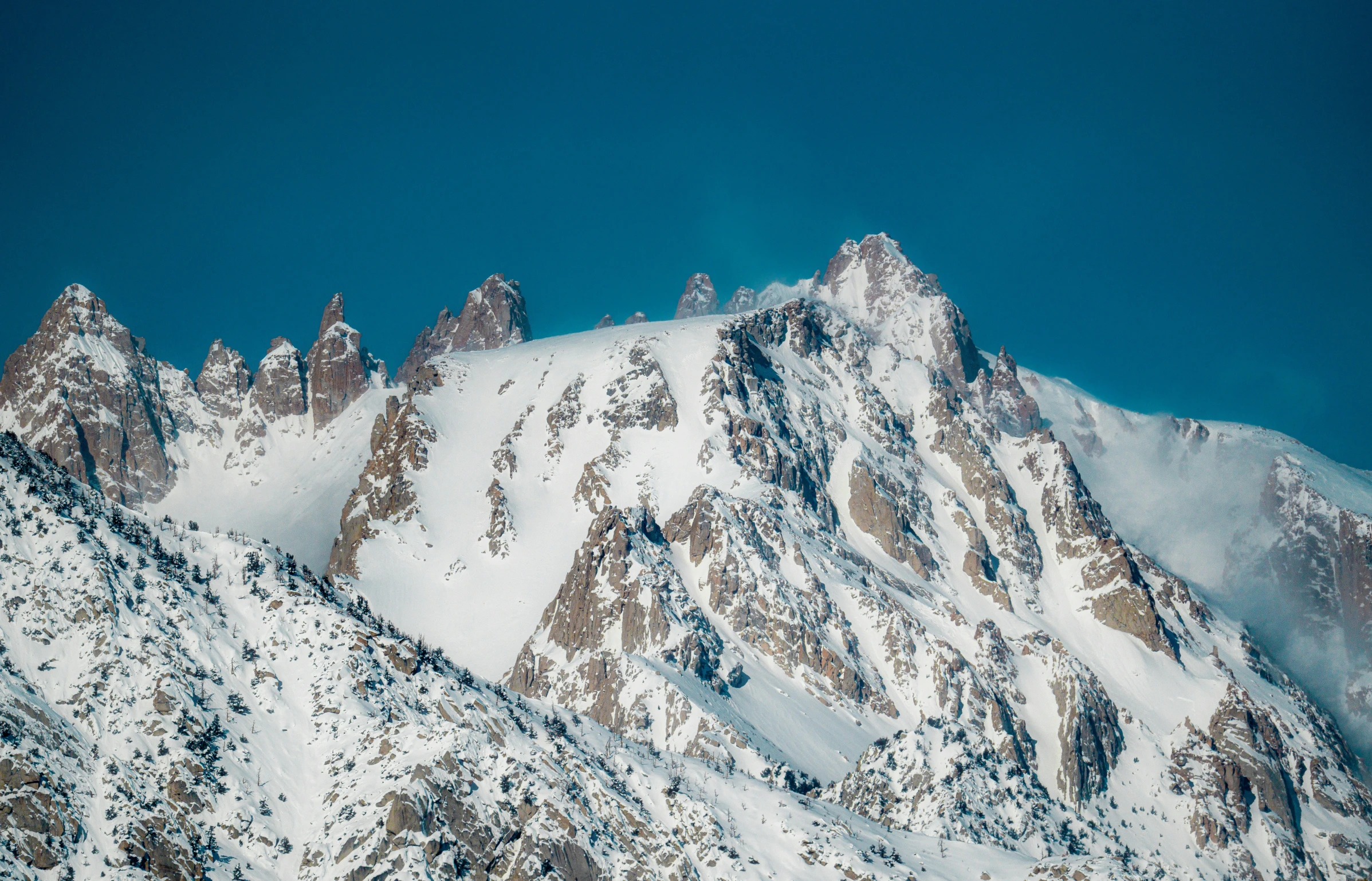 snow covered mountain tops are shown against the sky