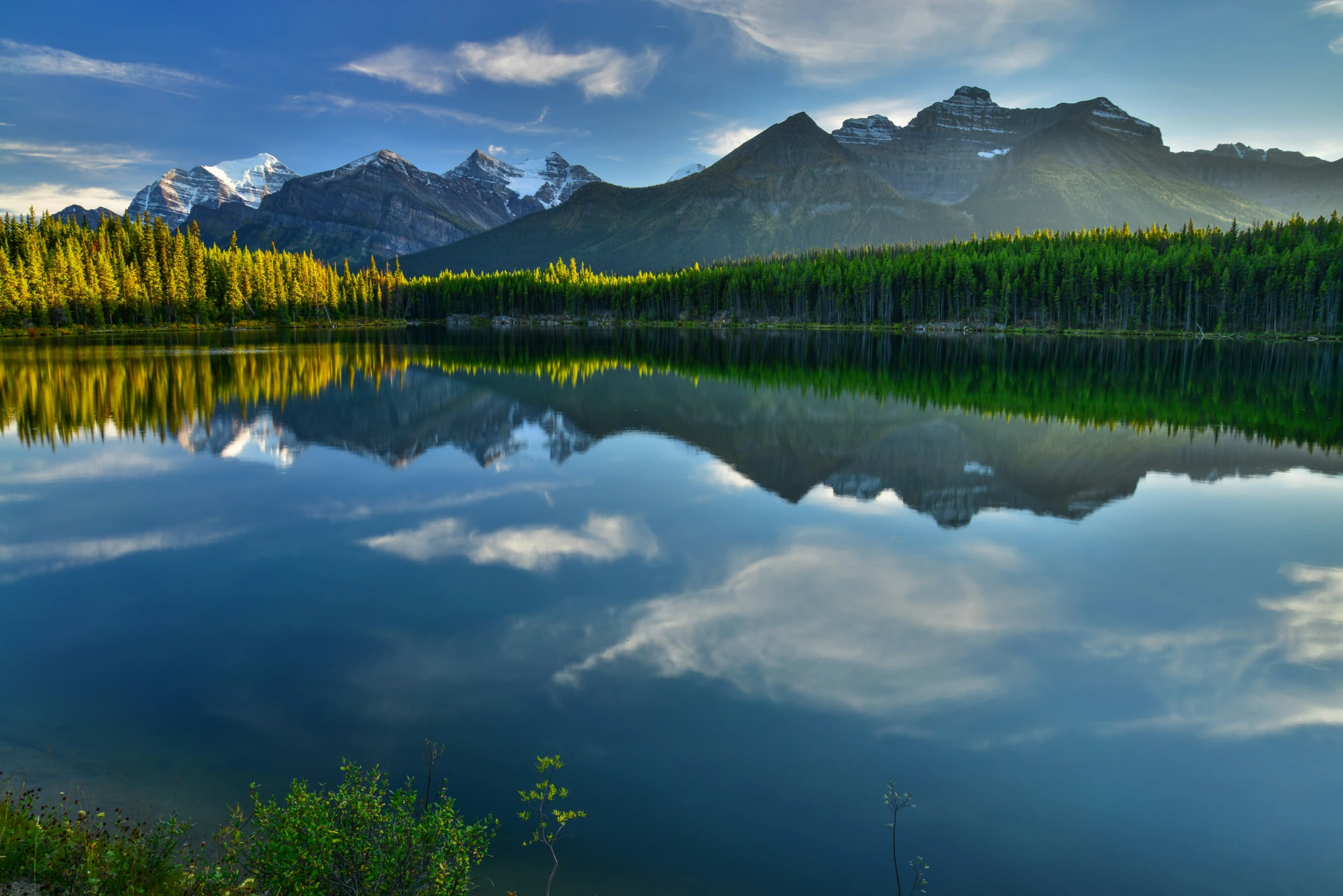 a mountain scene in the background and its reflection in the water