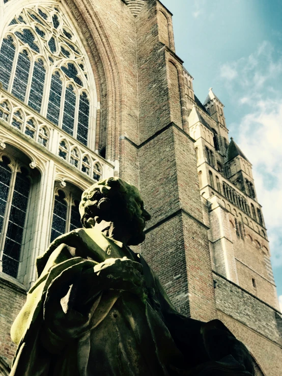 a statue sitting in front of a tall church