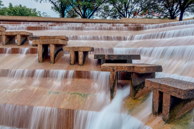 several park benches sitting in front of some water falls