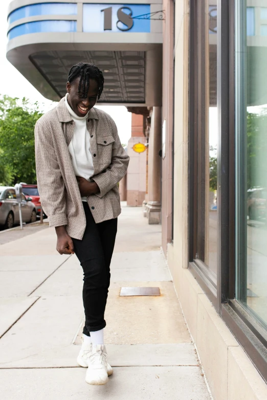 a man walking down a sidewalk next to a building