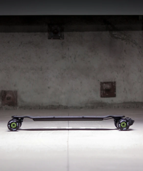 a skateboard with two green wheels sits against the wall