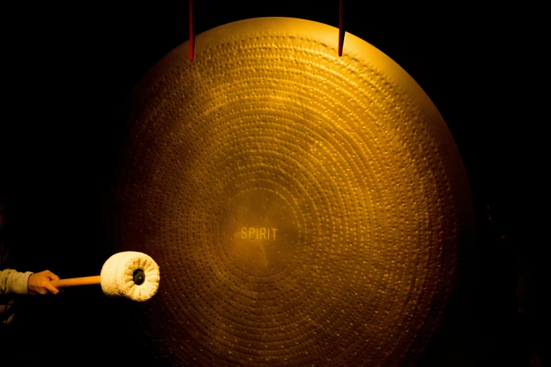 the young child holds a large item over a giant disc