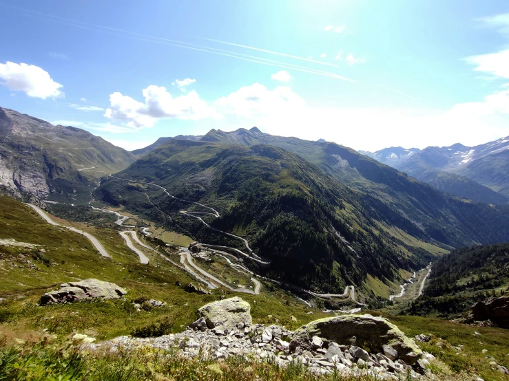 a green mountain top with roads winding in