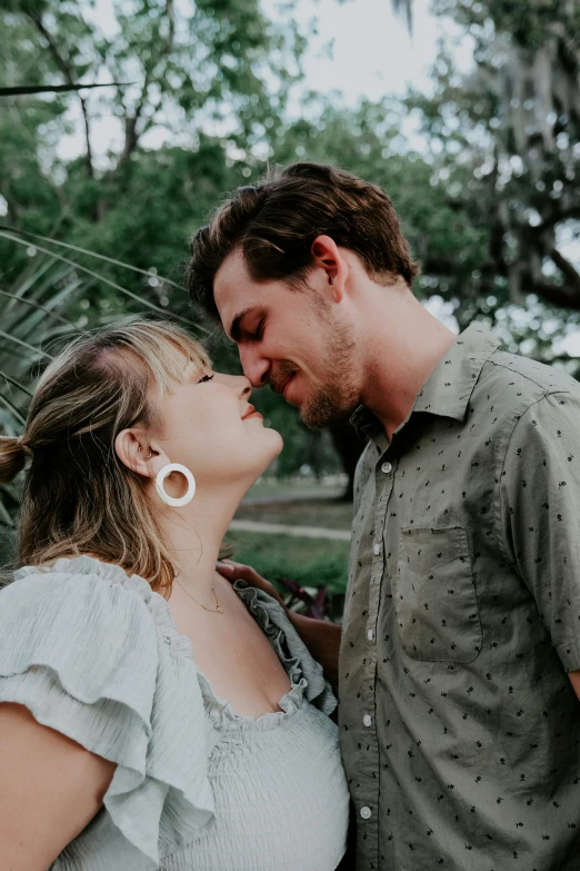 a couple smiling at each other in an outdoor setting