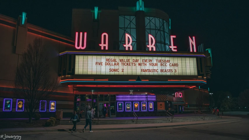 a theatre sign sitting above a theater entrance