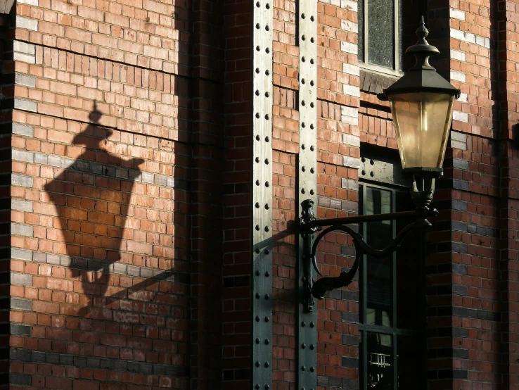 the shadow of a light fixture on a brick wall