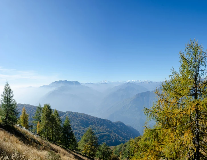 two men walk together on a trail overlooking a mountain