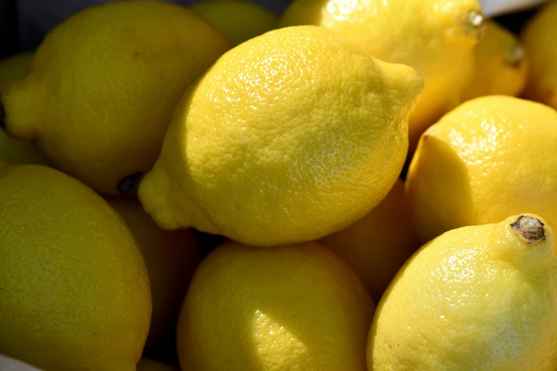 yellow lemons in a white bowl on display