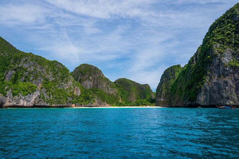 a small island on the ocean and a boat coming towards it