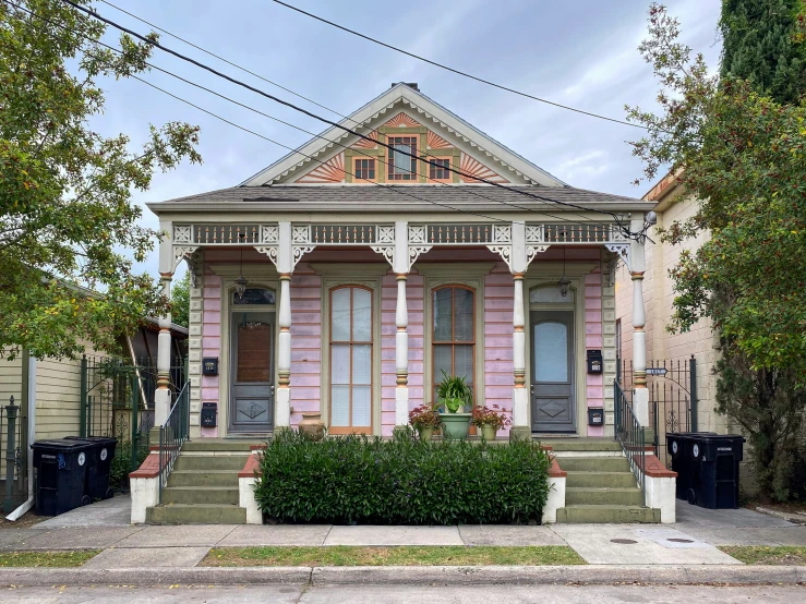 there is a pink house with several trees near it