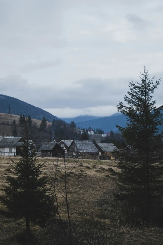 some small houses in the middle of a mountain with trees