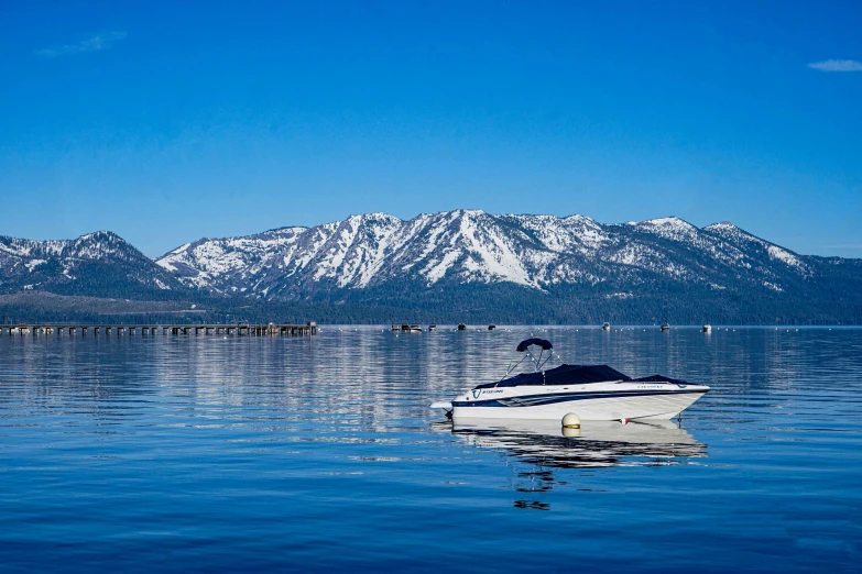 a boat on the water with mountains in the background