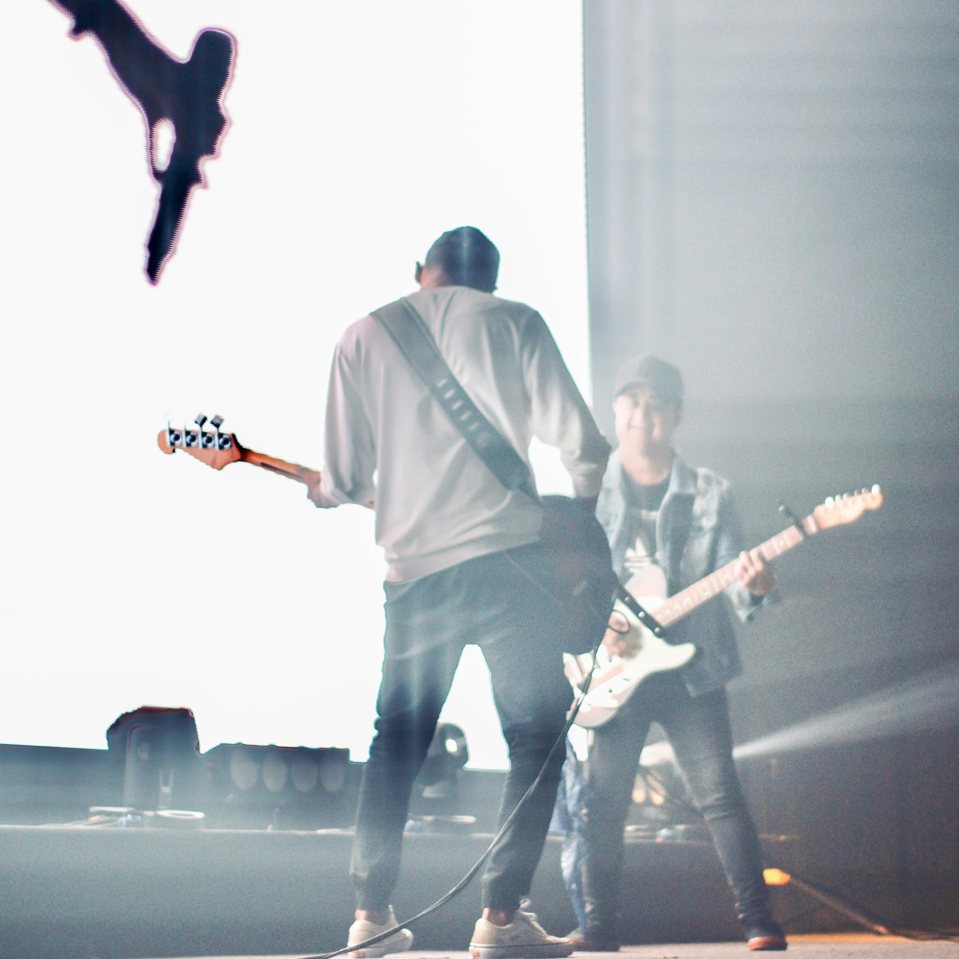 the three young men are performing with the guitar