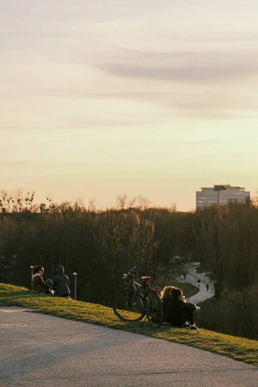 a group of people sitting on the ground with their bicycles