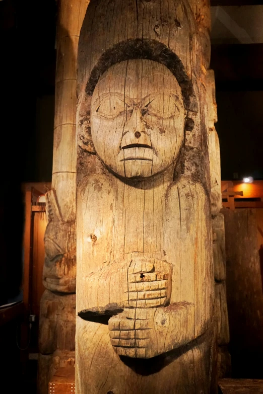 wooden carvings depicting a human face and hands