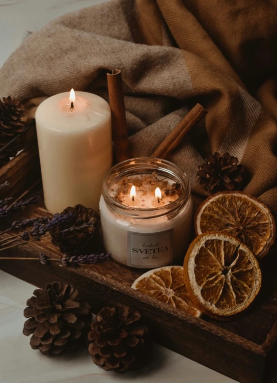 a candle and a set of fruits on a table