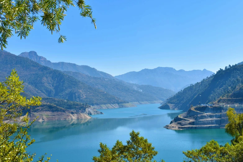 a lake is surrounded by hills, forests and trees