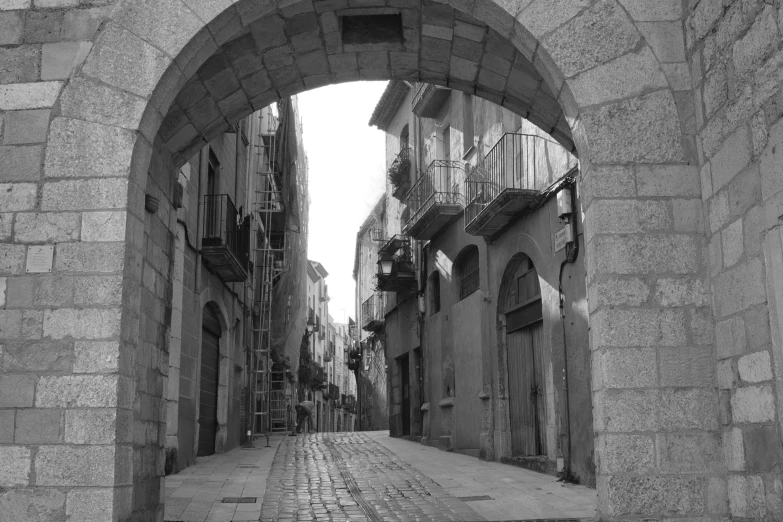 the entrance to a city street with a stone arch