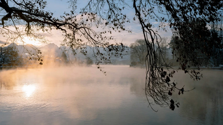 fog rises from the river in winter at dawn