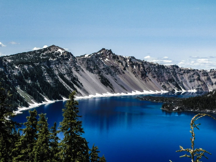 the blue water is surrounded by snow capped mountains