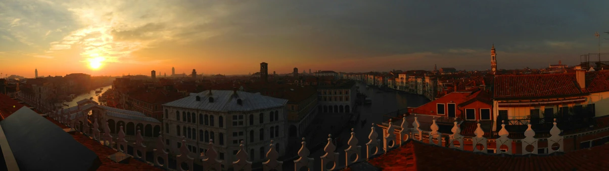 the sun is rising over the skyline from the top of the building