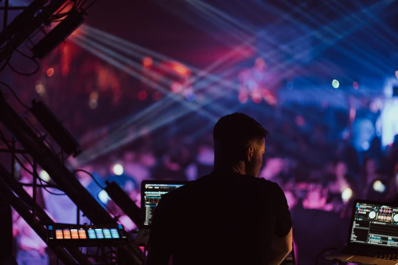 a man is recording a concert in front of a laptop