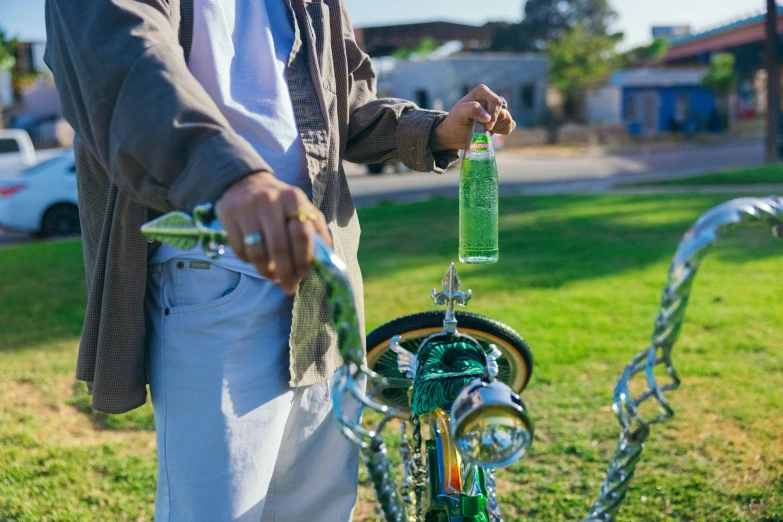 a man holds a plastic bottle on the back of his bicycle