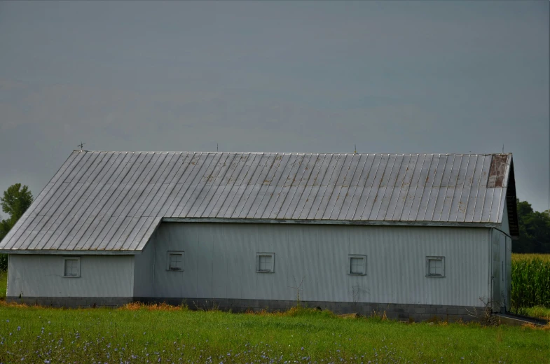 a metal barn with two silos and no roof