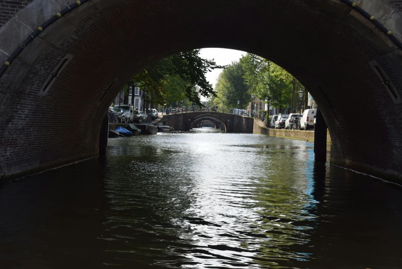 a boat traveling under a brick bridge