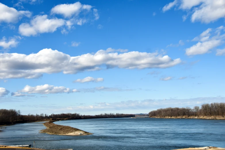 a body of water with many clouds in the sky