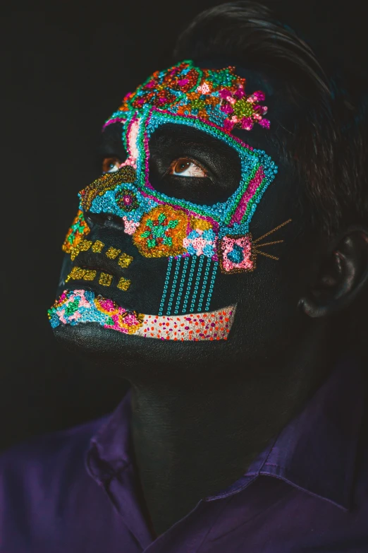 a man with dark skin wearing a skull mask