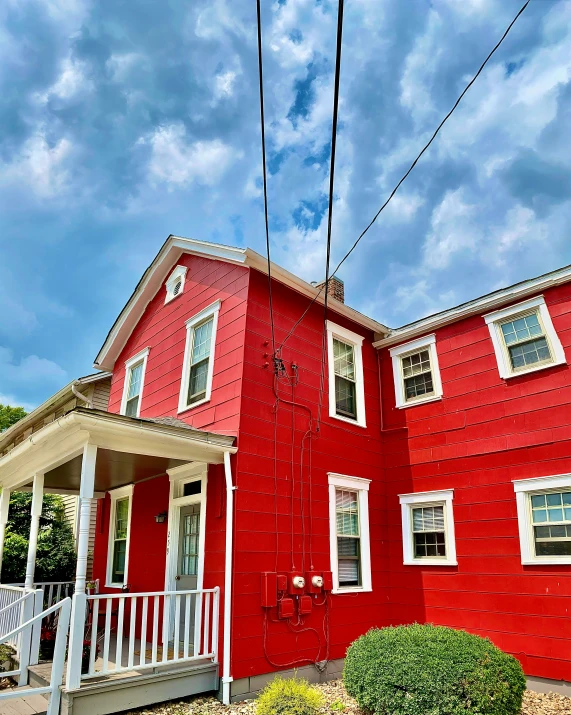 red house with white trim on the front of the building