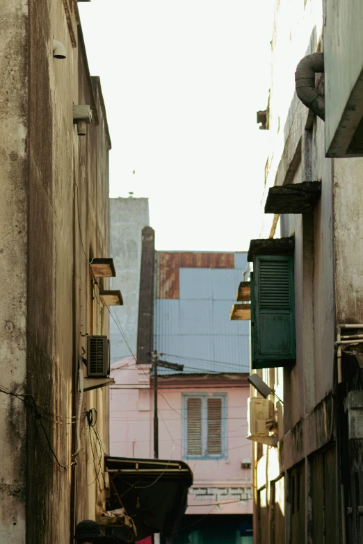 a narrow street with buildings and windows in the distance