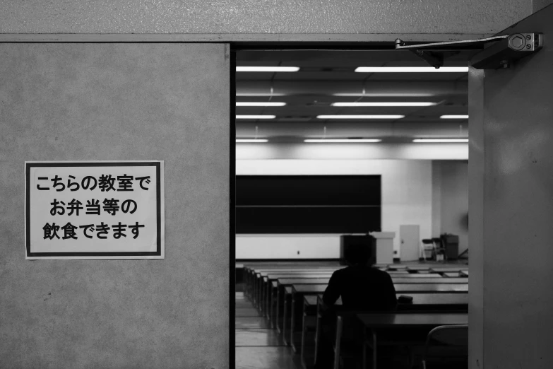 a man sitting at a table in a room full of desks