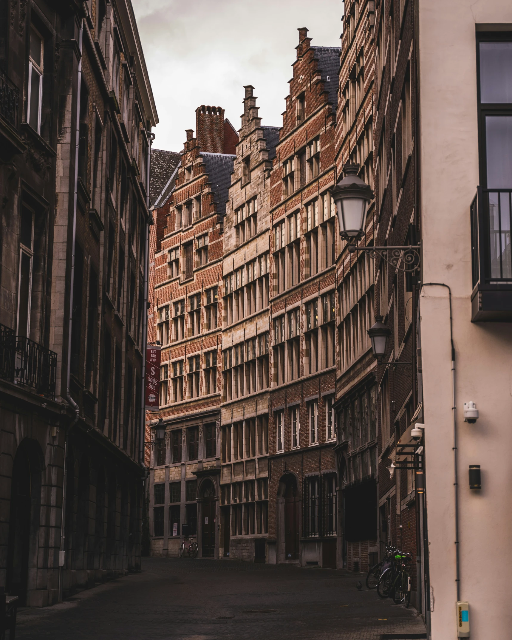 a narrow street in an old city with a clock