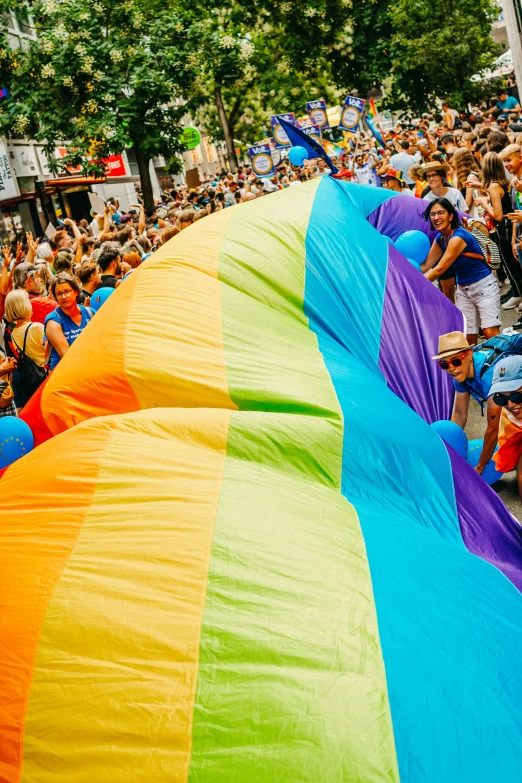 a large multi - colored kite with the rainbow finish at an outdoor event