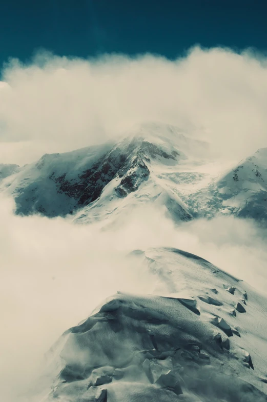 the view from above of a mountain with clouds