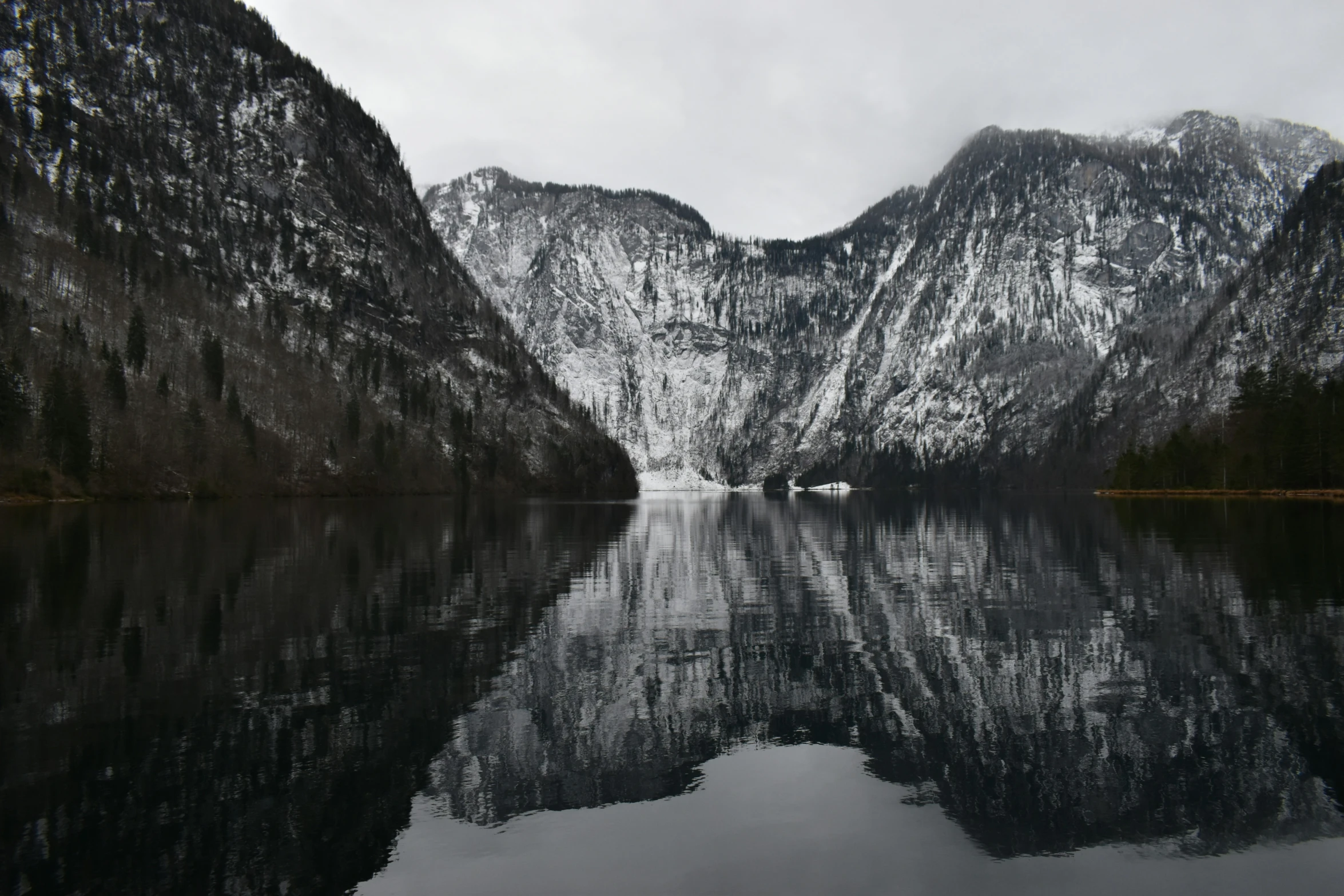 the water is still full as it reflects a snowy mountain