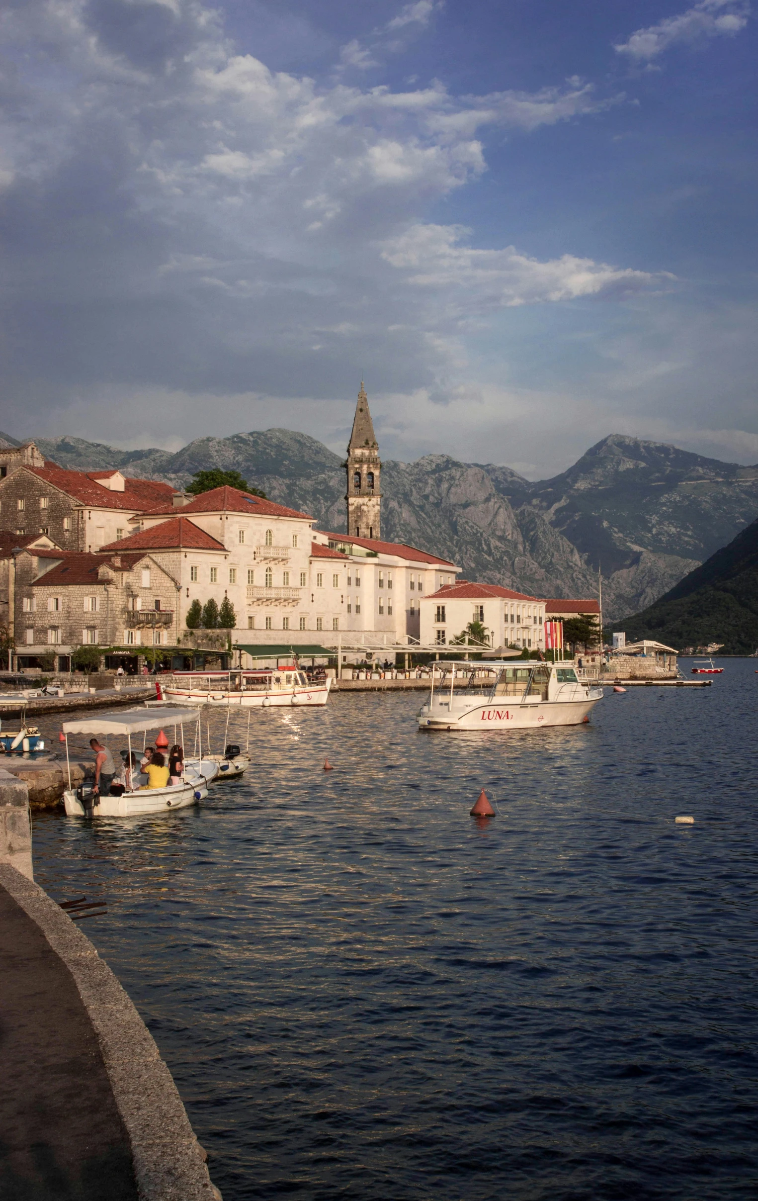 a harbor with many boats and buildings and hills in the background