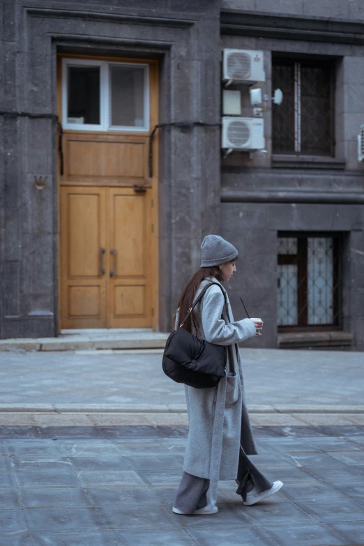 a woman walking down the street with her hand in her pocket