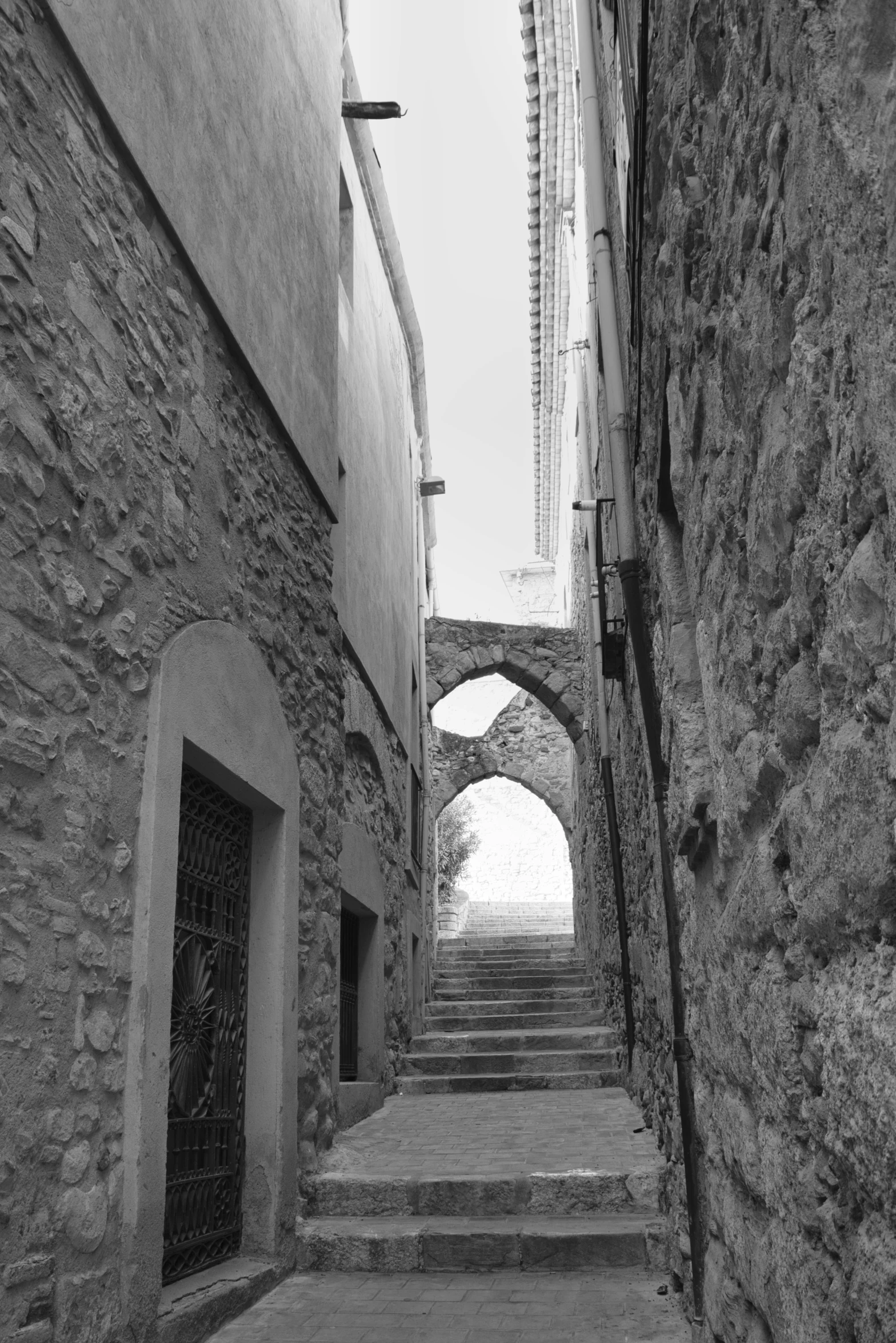 two stone steps that go down a narrow alley way