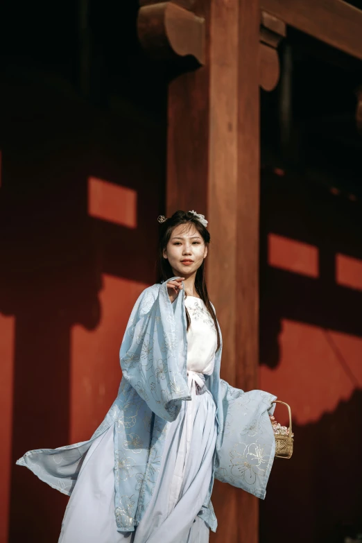 woman wearing oriental clothes standing in front of the temple