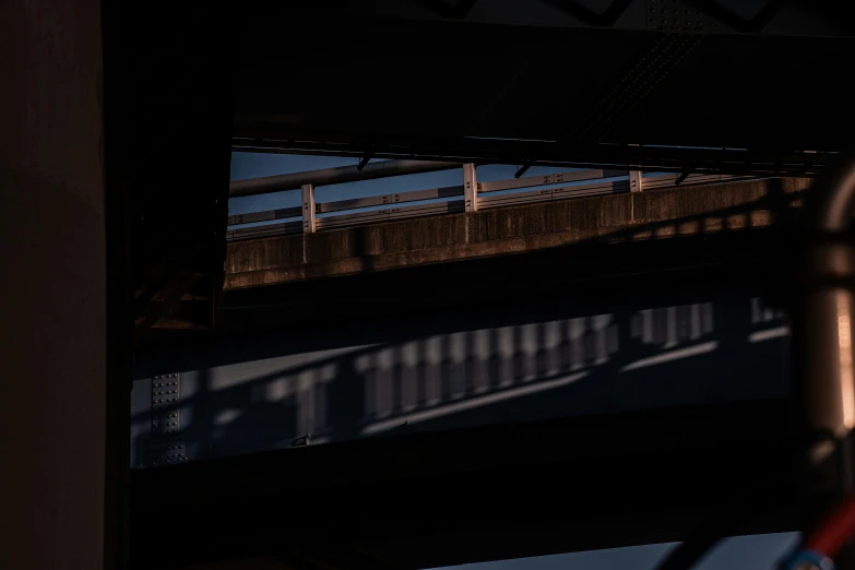 a train passes under an overhead bridge