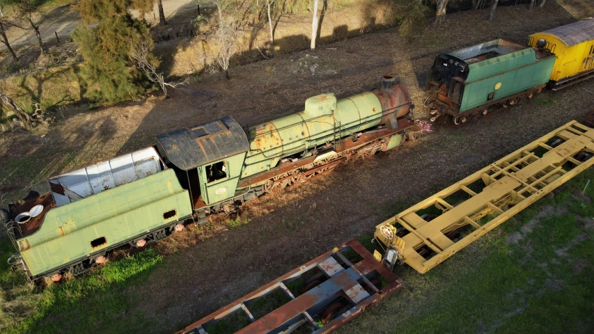 three abandoned train cars sit on the railroad tracks