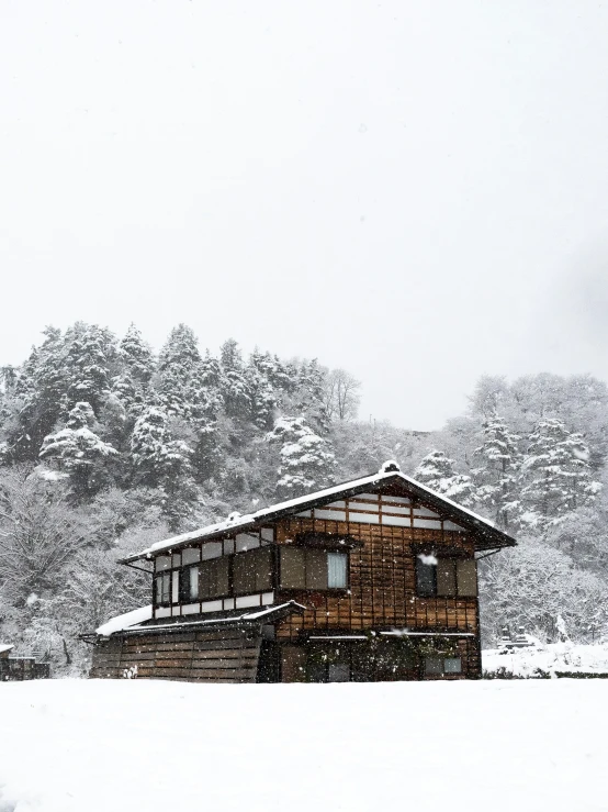 a small cabin sits near a snowy hillside