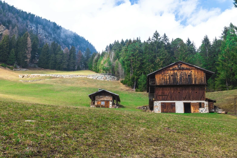 two cabins in the middle of a grassy field